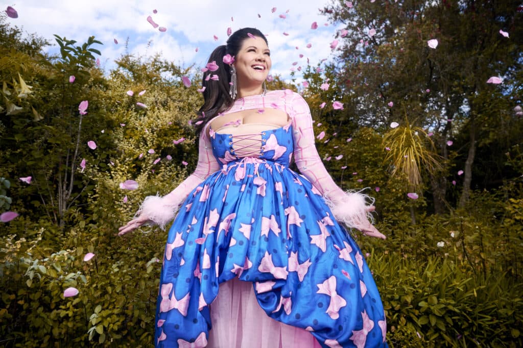 Tanya Hennessy amidst a string of pink petals mid-air.