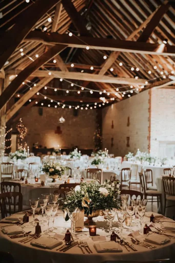 Rustic destination wedding reception held in a barn with fairy lights 