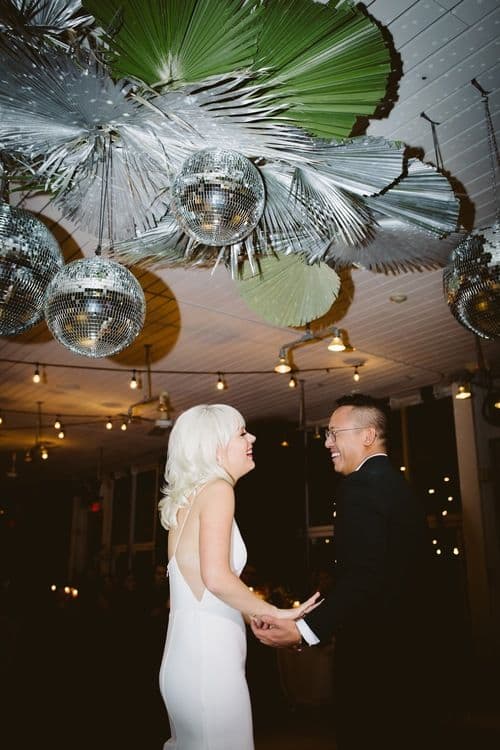 Newly married couple in retro-inspired wedding reception venue