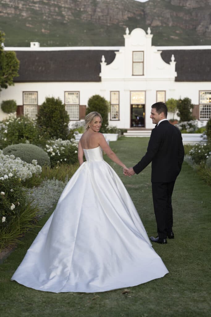 Bride and groom, holding hands at the Cape Town venue