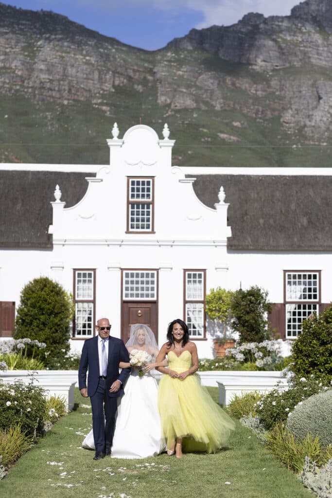 Bride being walked down the aisle by her mother and father