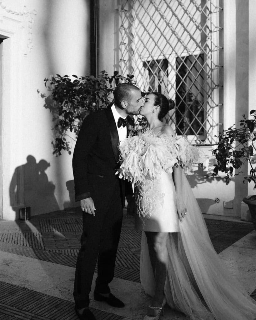 A bride and groom kissing at sunset. 