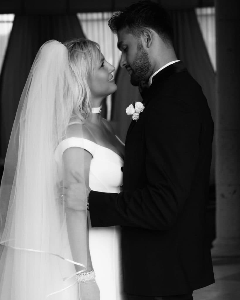 Bride and groom wearing classic wedding outfits in black and white picture