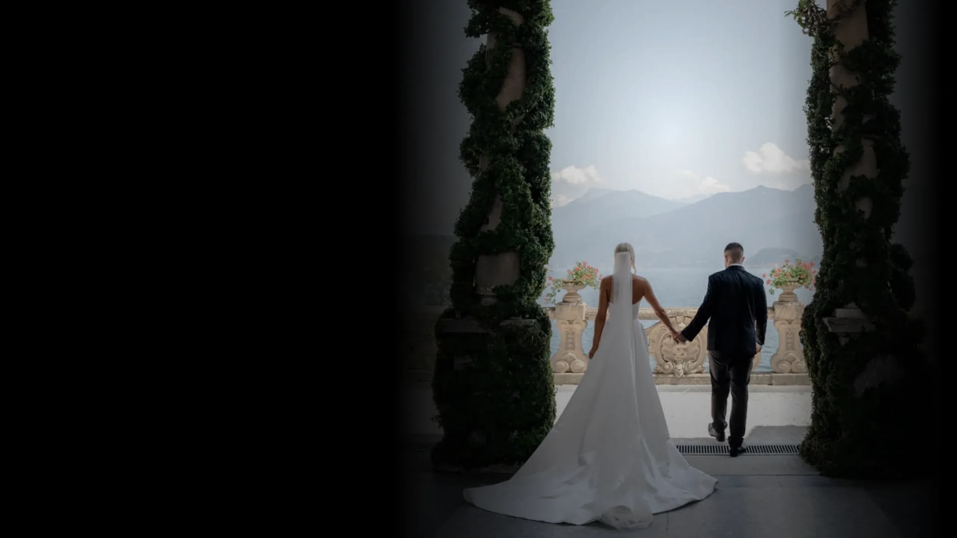 Elegant wedding couple walking through an ornate garden archway