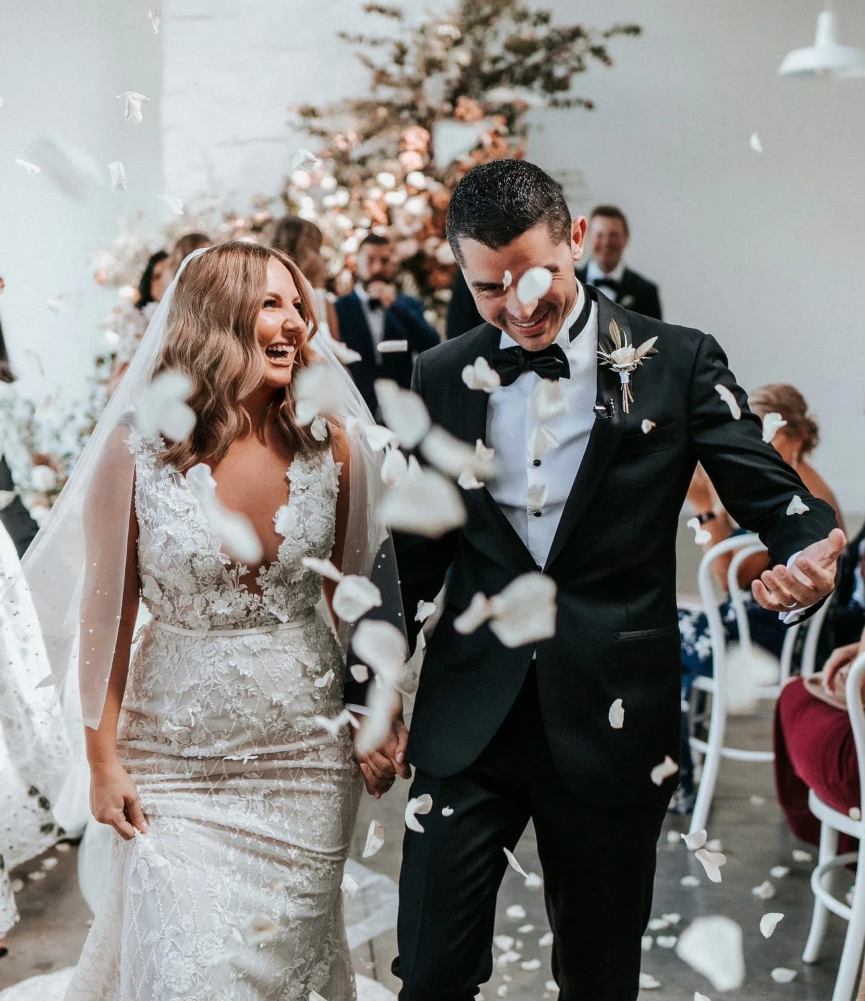 Wedding couple walking with rose petals