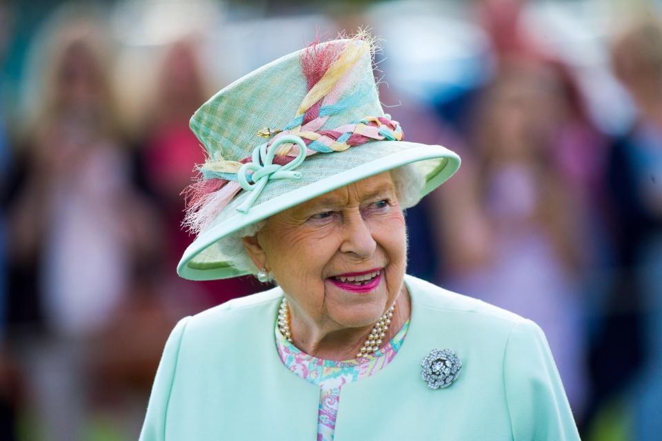 Queen Elizabeth wearing light blue and smiling