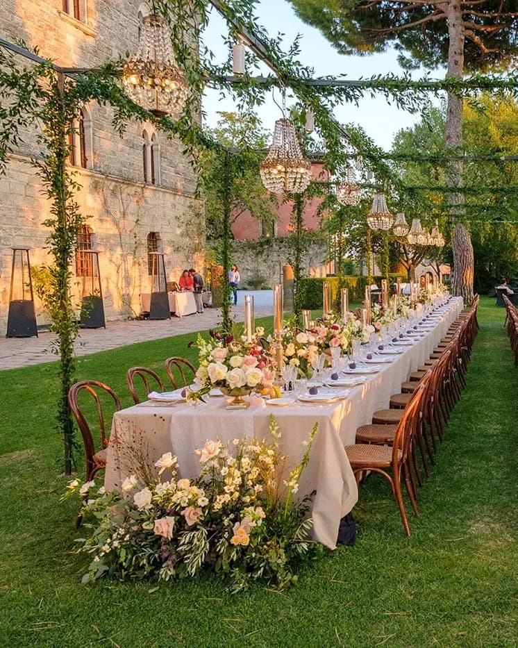 Long wedding tables beneath a pergola on a Tuscan estate