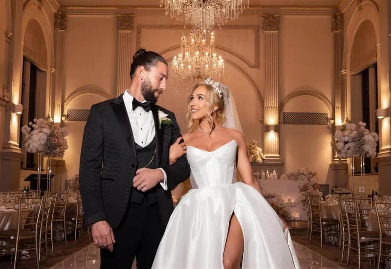 A bride and groom in a candlelit ballroom