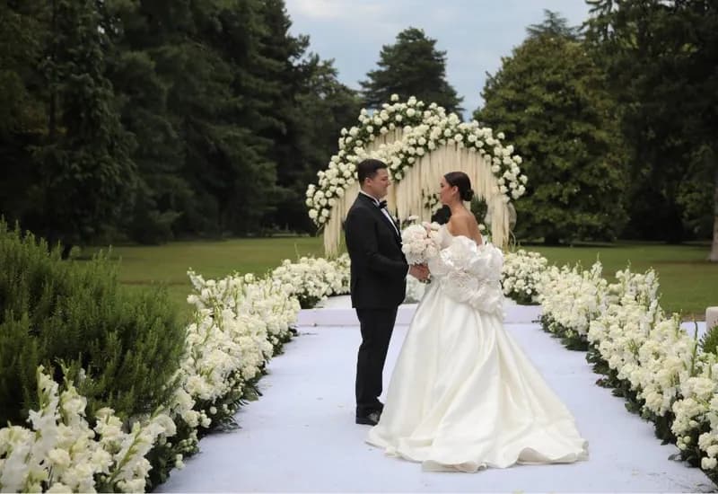 A couple beneath a floral arch on a garden estate