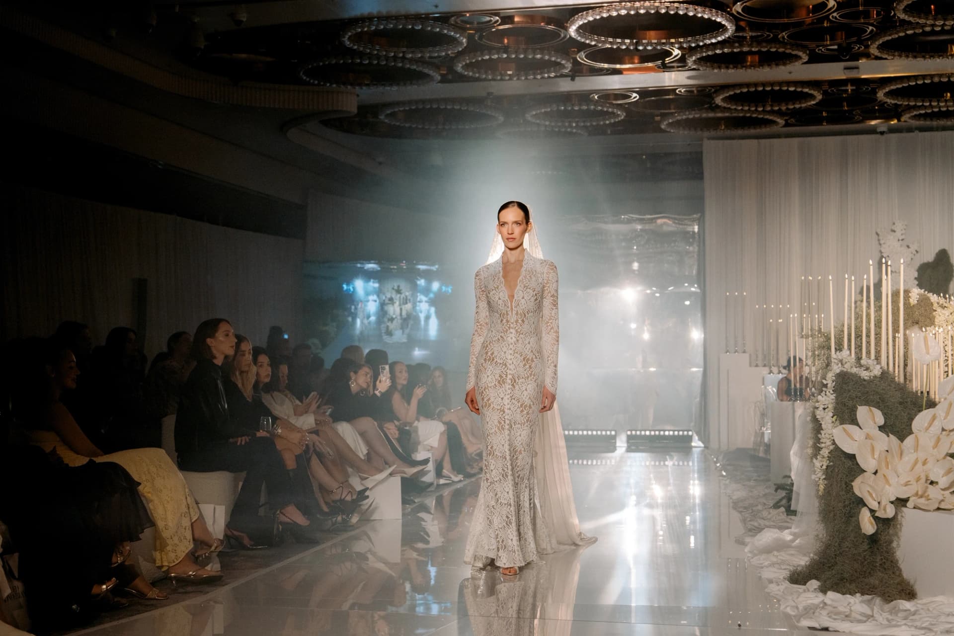 A model in a lace bridal gown on the international couture runway at Wedded World