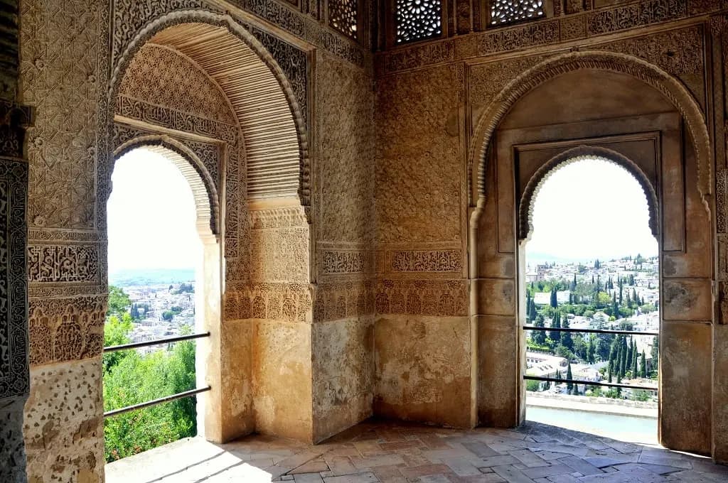 Carved Nasrid arches framing a view over Granada from the Alhambra