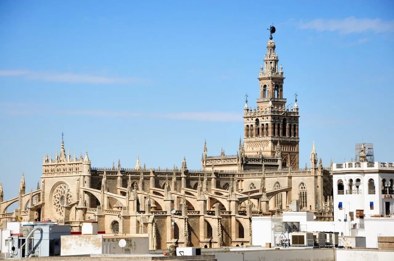 Seville Cathedral and the Giralda bell tower under a blue sky