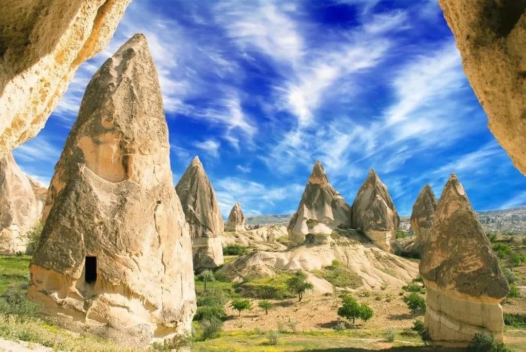 Cone-shaped fairy chimneys in a green valley in Cappadocia