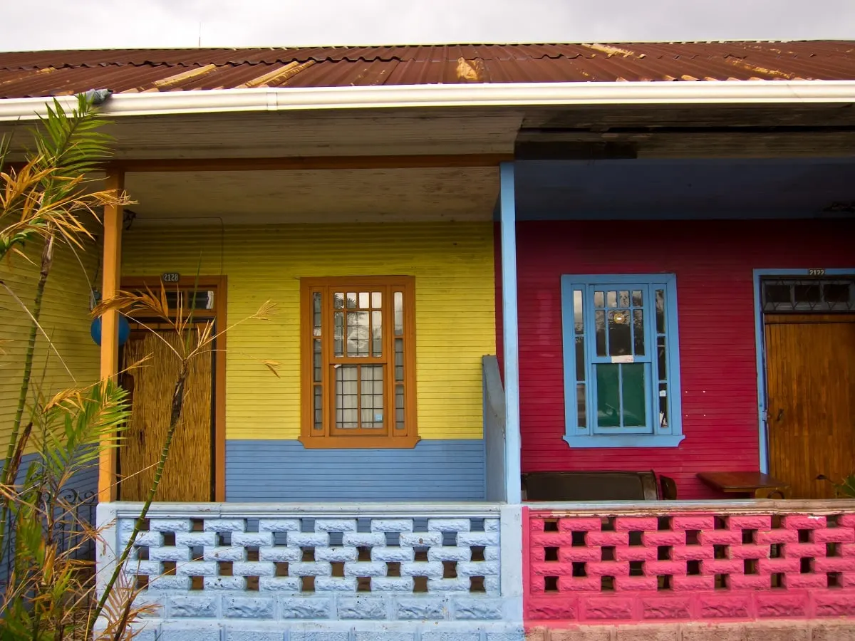 A yellow and red painted country house with a wooden porch