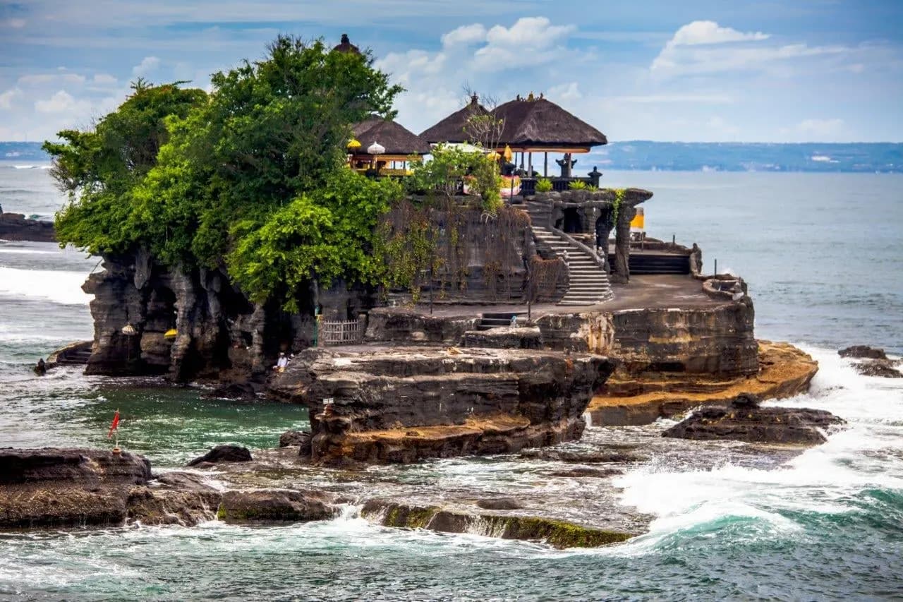 Tanah Lot temple on its rock island with waves breaking around it