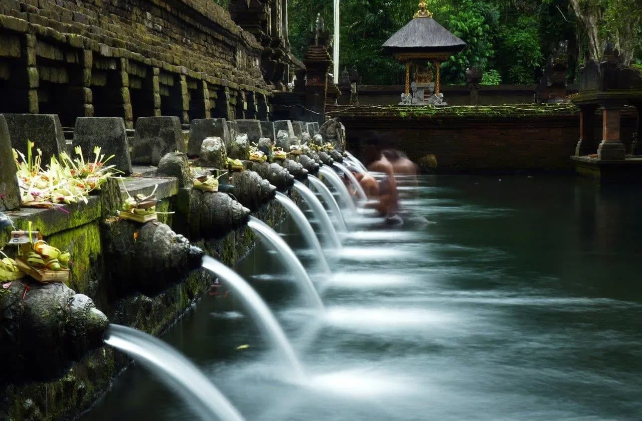 Stone spouts pouring spring water into a temple bathing pool