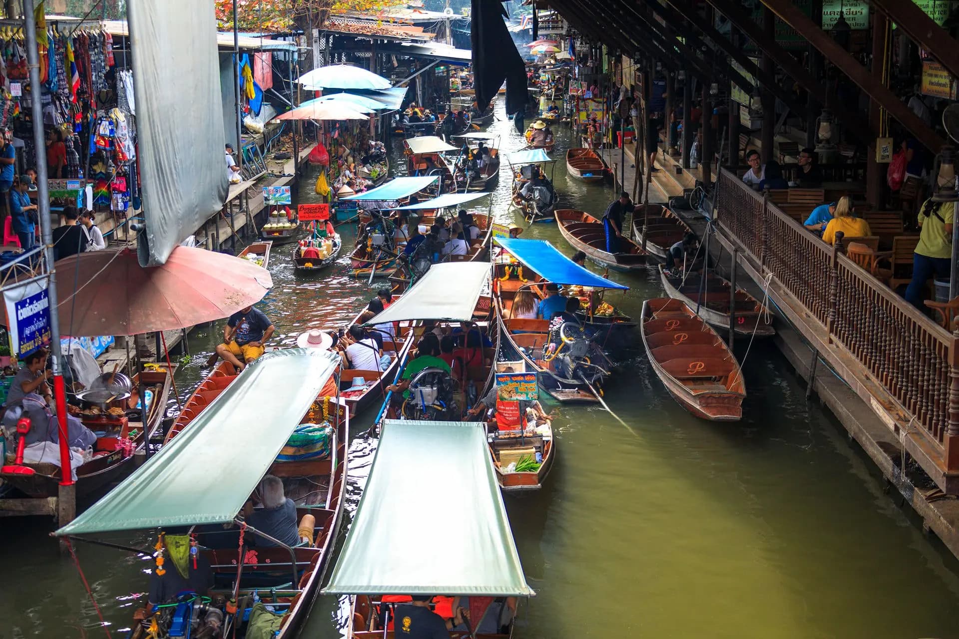 Boats and stalls crowding a canal at the Damnoen Saduak floating market