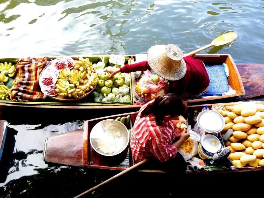 Two market boats loaded with fruit and snacks, seen from above