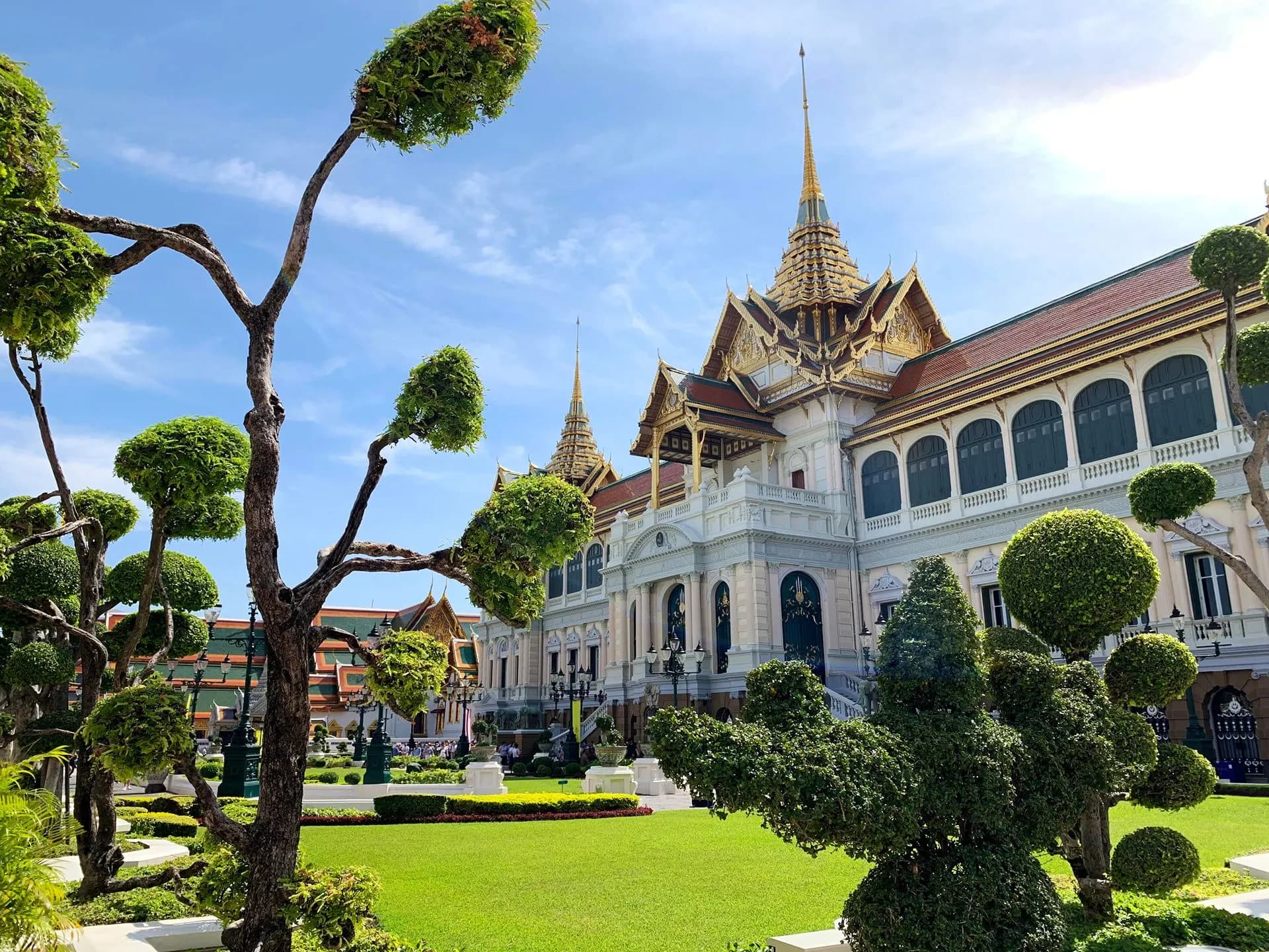 The Grand Palace in Bangkok behind clipped trees and lawns