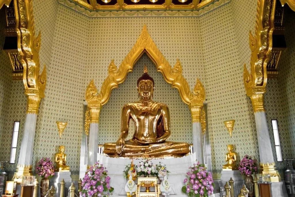 A seated golden Buddha in a white and gold shrine