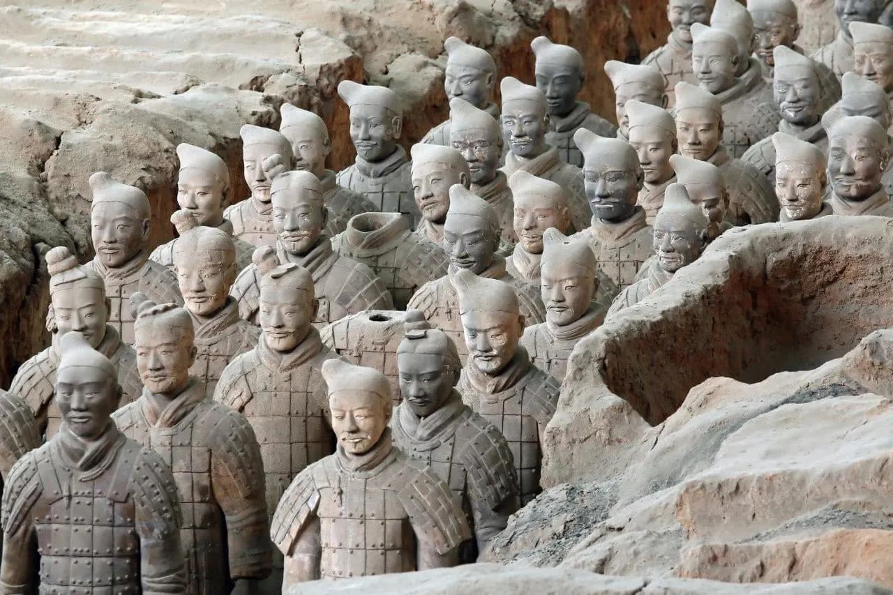 Rows of terracotta warriors standing in an excavated pit at Xi'an