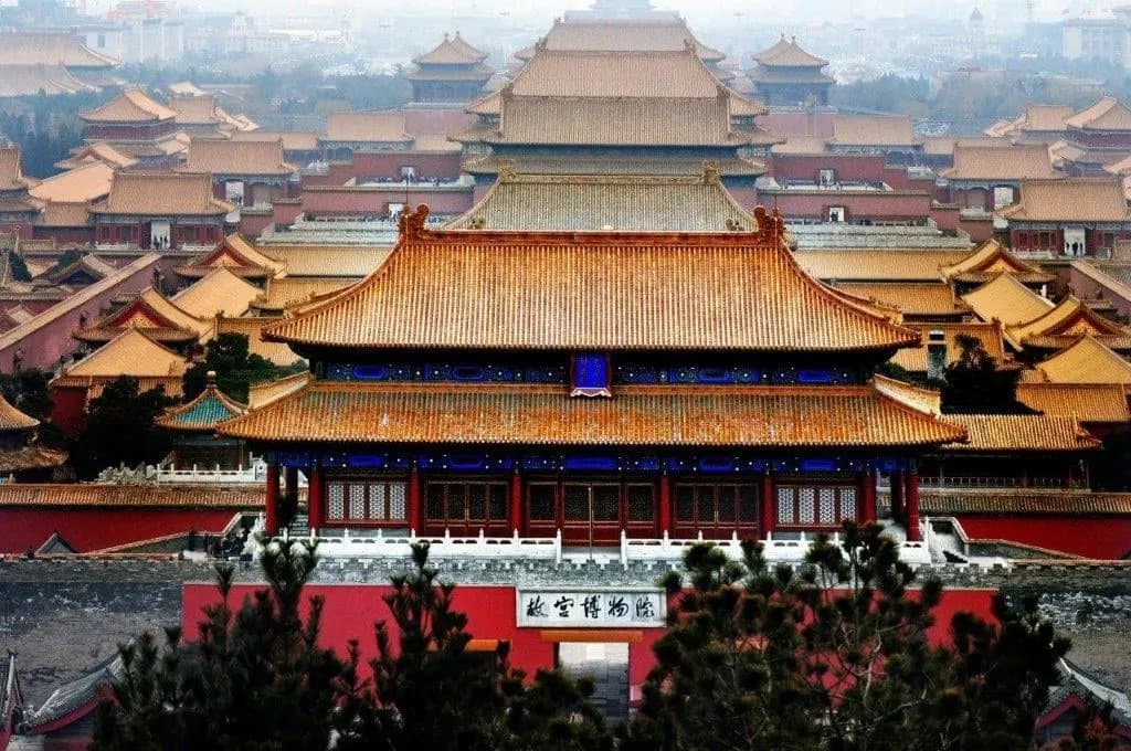 Golden roofs of the Forbidden City stretching back from a red gate