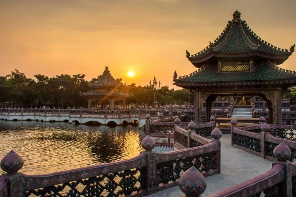 A traditional pavilion and lakeside terrace at sunset