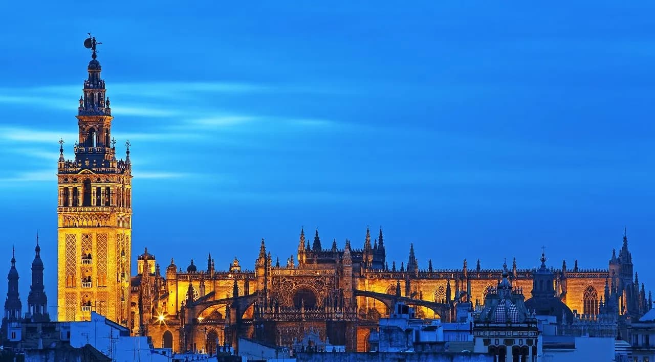 Seville Cathedral and the Giralda floodlit at dusk