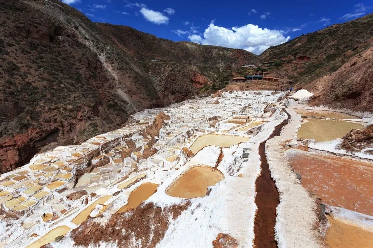 Hundreds of white salt pans stepping down a valley at Maras