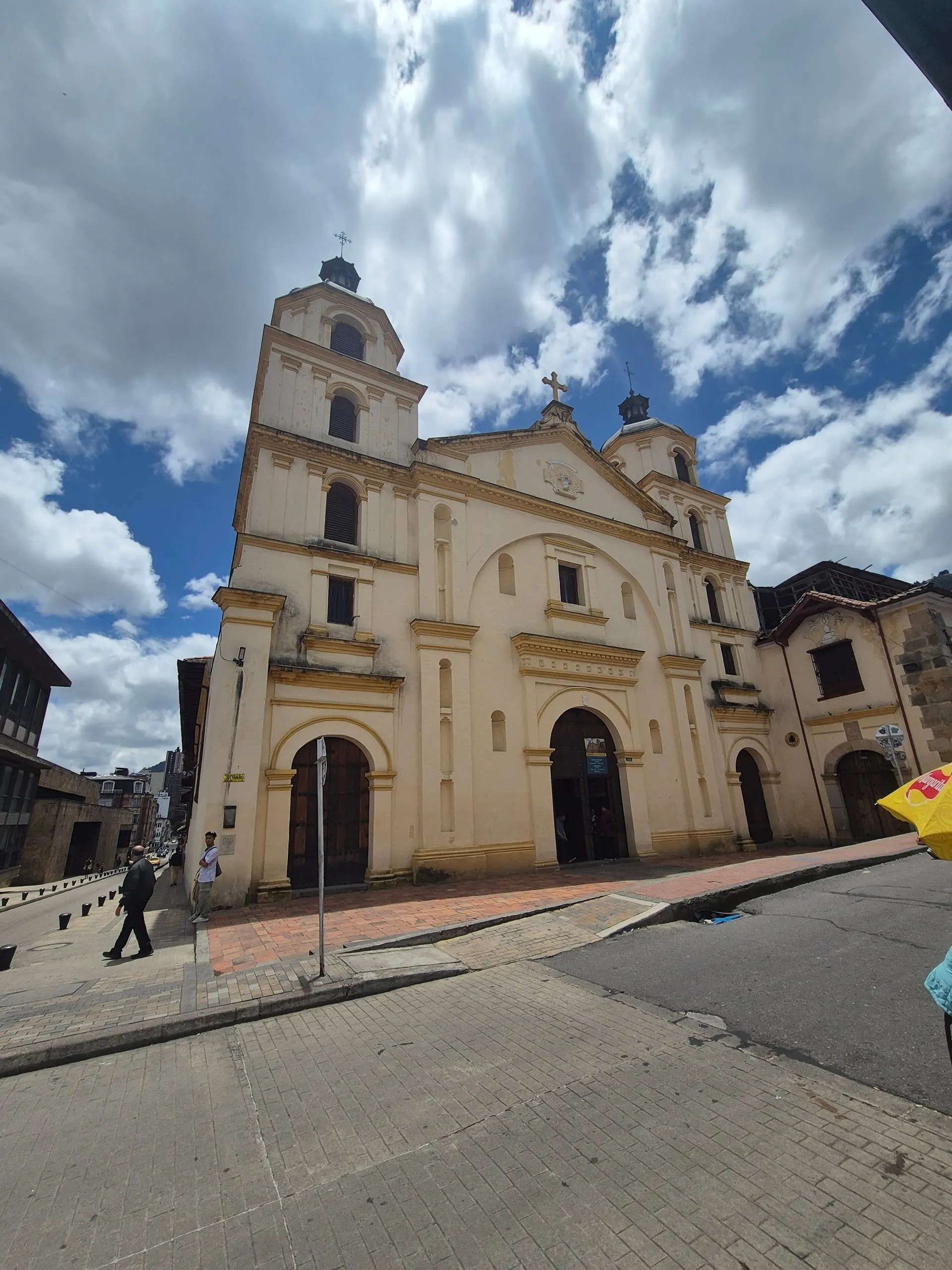 A cream colonial church with a bell tower against a blue sky