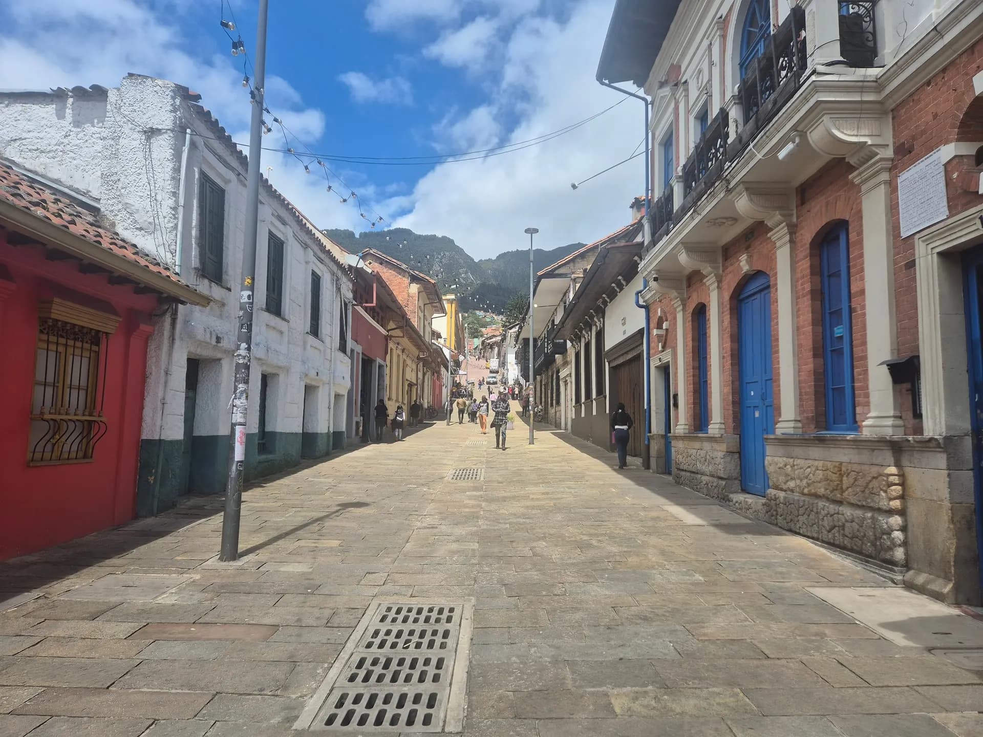 A quiet colonial street in La Candelaria with green hills beyond