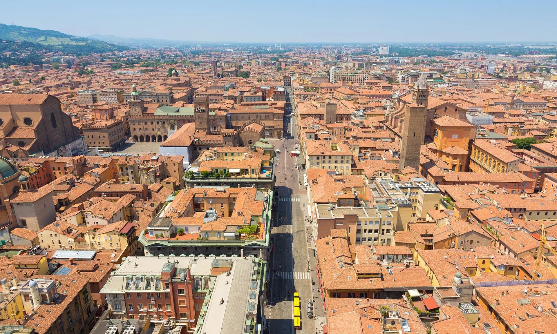 Red rooftops and towers stretching across Bologna towards the hills