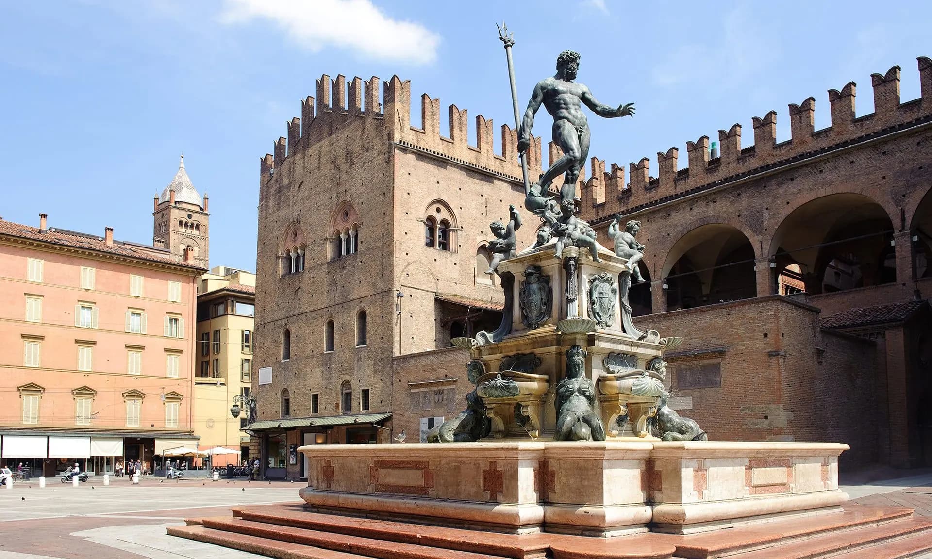 The bronze Fountain of Neptune in front of a crenellated palace in Bologna