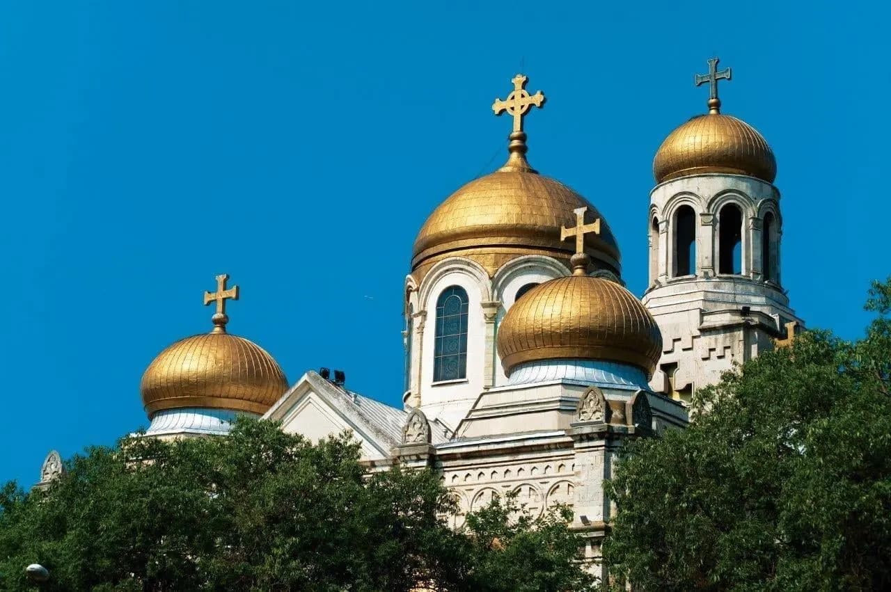 Gilded domes of an Orthodox cathedral against a clear blue sky