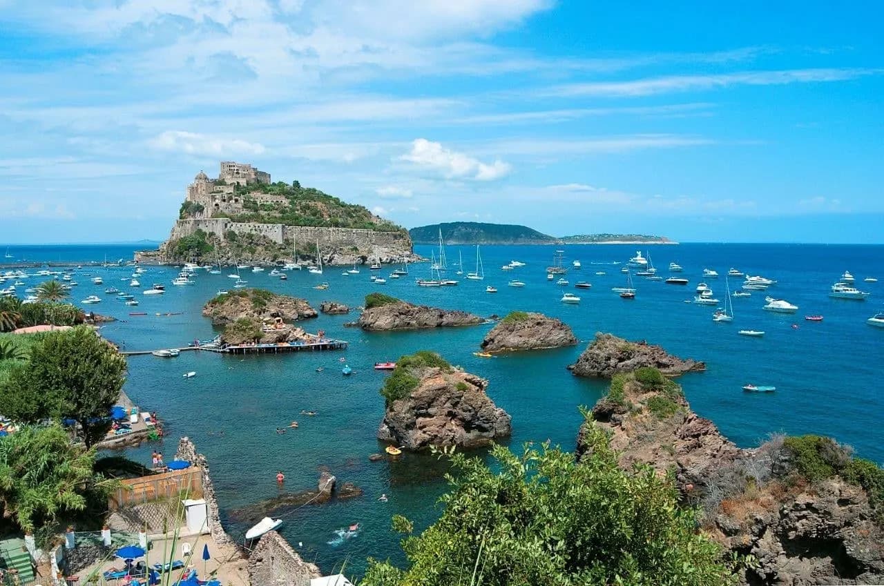 Looking down on the Aragonese Castle and sailing boats in the clear water off Ischia