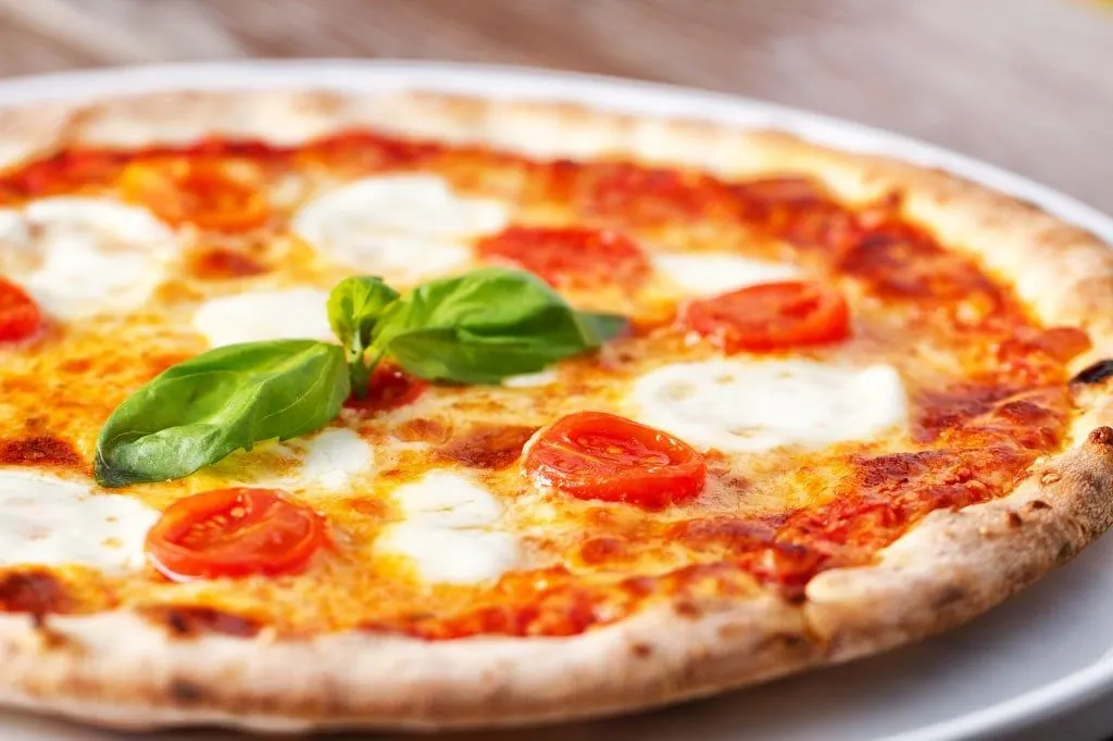 A Neapolitan pizza margherita with basil and mozzarella