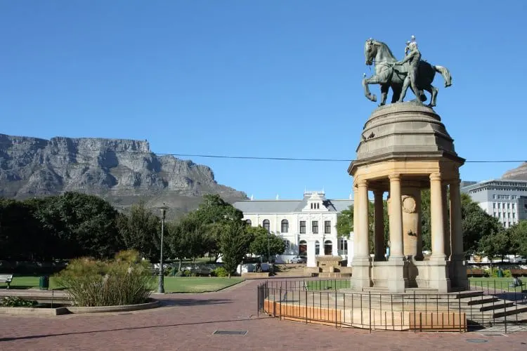An equestrian memorial in a city garden, with Table Mountain behind