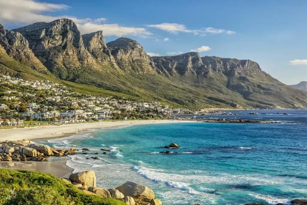 The beach and turquoise water of Camps Bay below the Twelve Apostles