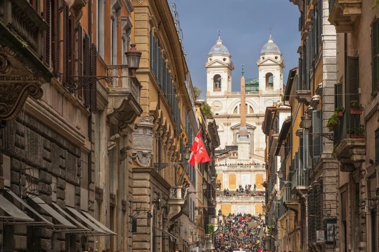 A Rome street leading to the Spanish Steps and the twin towers of Trinità dei Monti