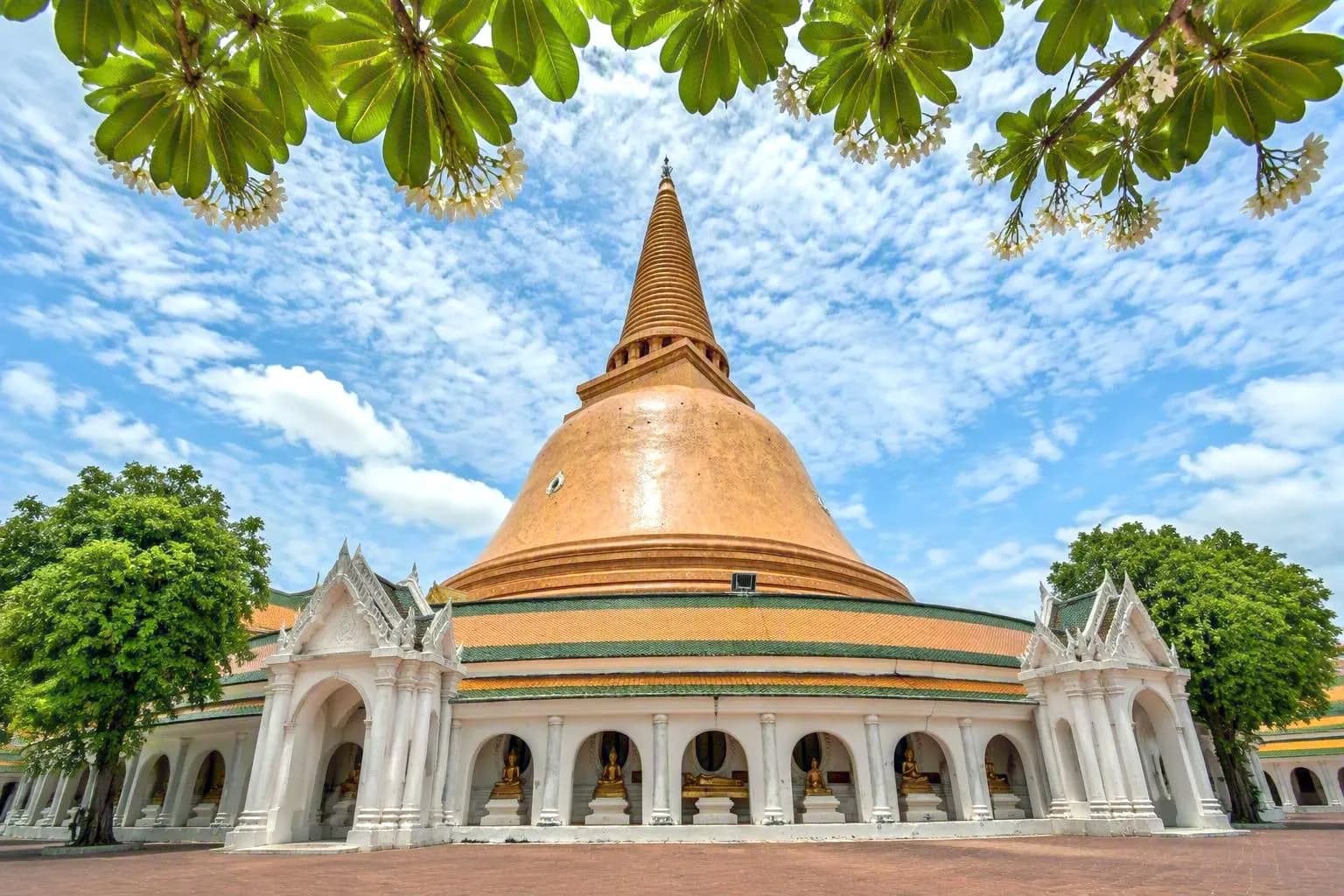 The golden dome of Phra Pathom Chedi framed by frangipani leaves