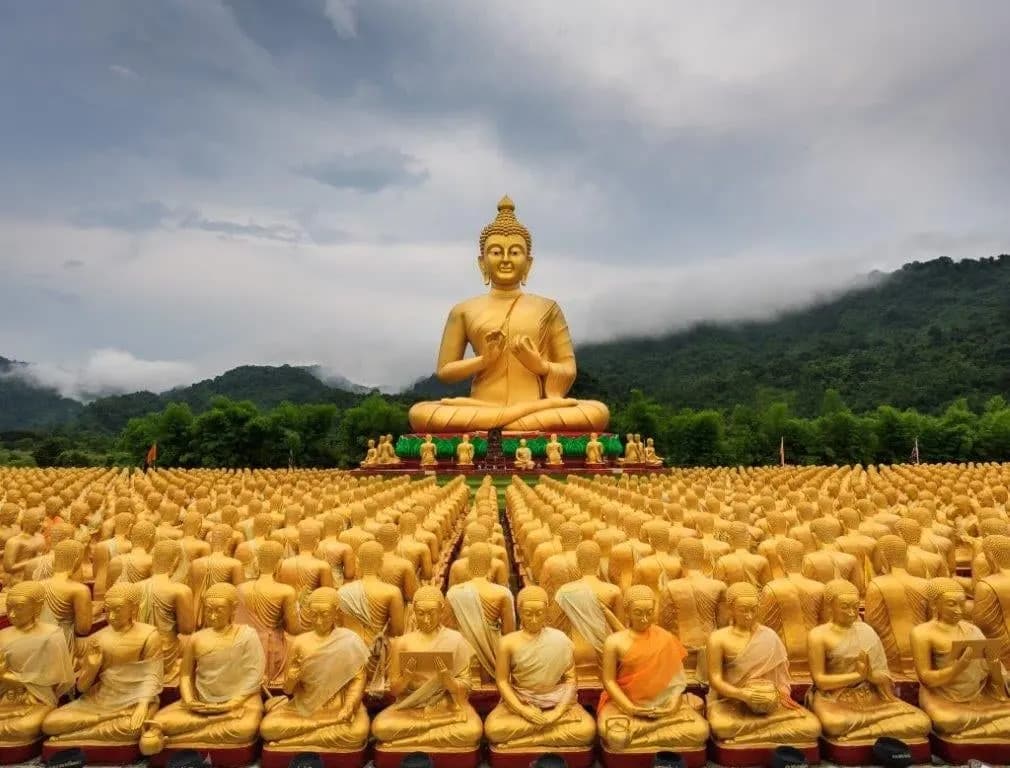 A large golden Buddha above rows of smaller golden statues