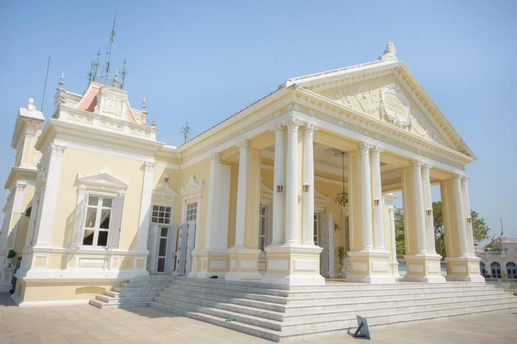A white neoclassical palace hall with columns under a clear sky