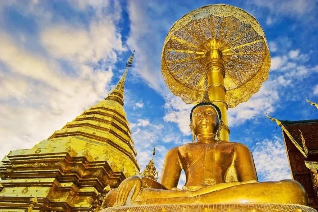 The golden chedi and a seated Buddha at Wat Phra That Doi Suthep