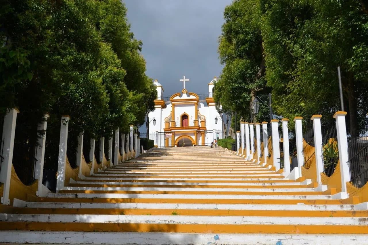 Long yellow and white steps climbing to a hilltop church in San Cristóbal de las Casas