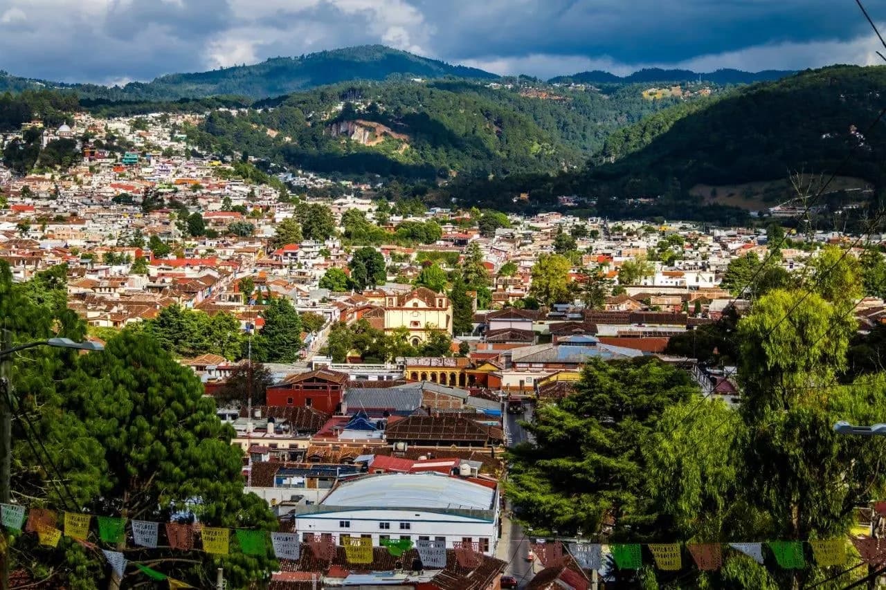 The rooftops of San Cristobal de las Casas below green hills