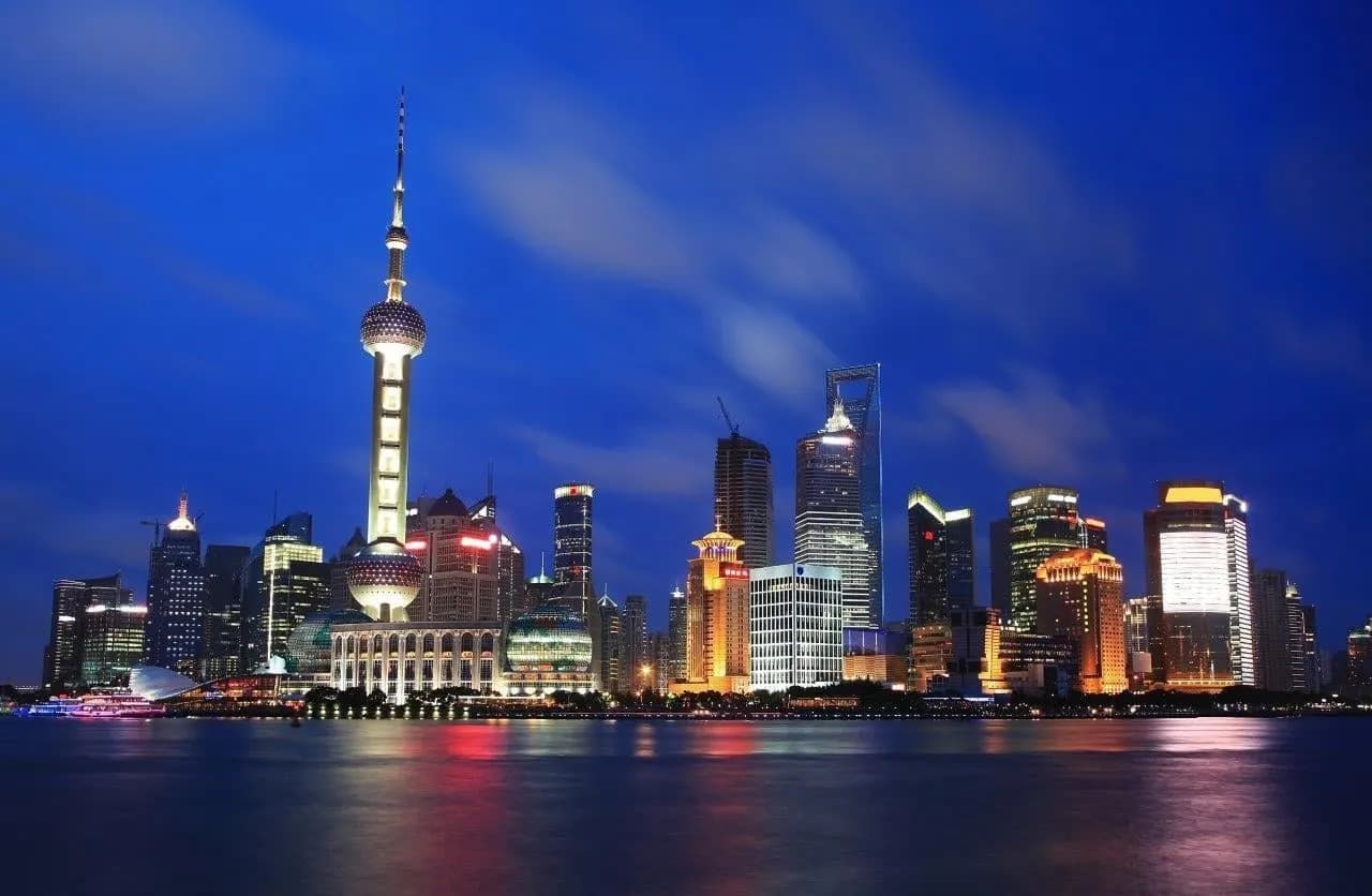 The Pudong skyline and the Oriental Pearl Tower lit up across the river at night
