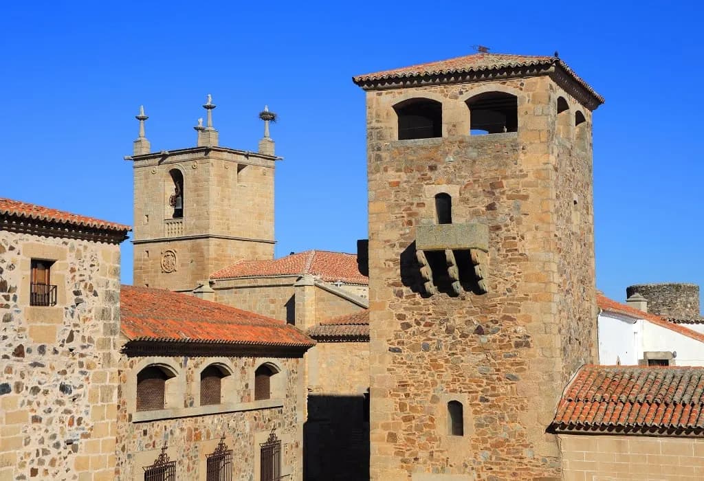 Stone towers and palaces in the old town of Cáceres under a blue sky