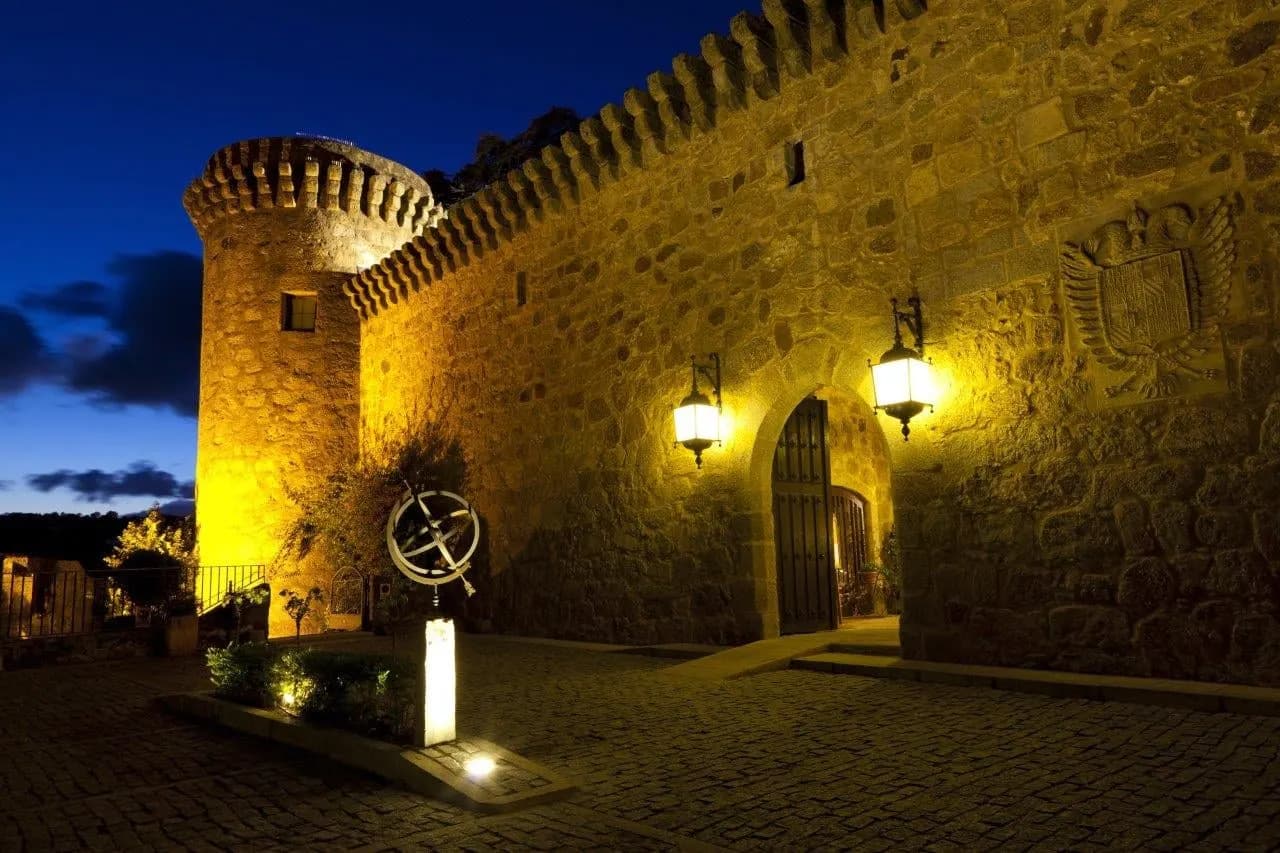 Floodlit castle walls and a round tower at night