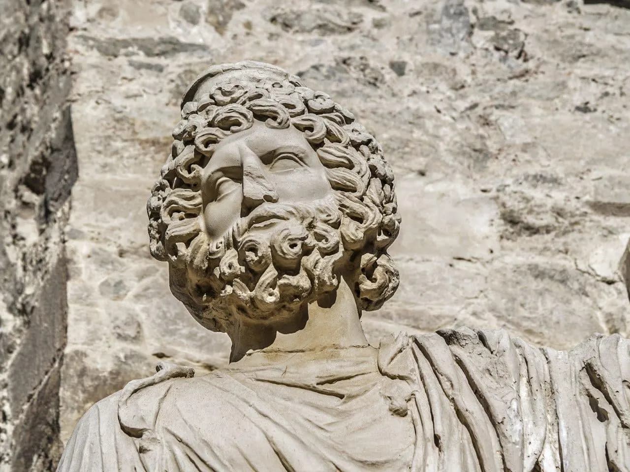 A carved Roman stone head of a bearded figure