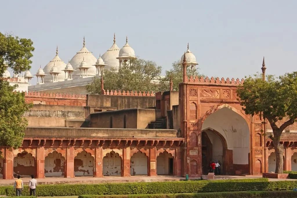 Red sandstone walls of Agra Fort with white marble domes behind